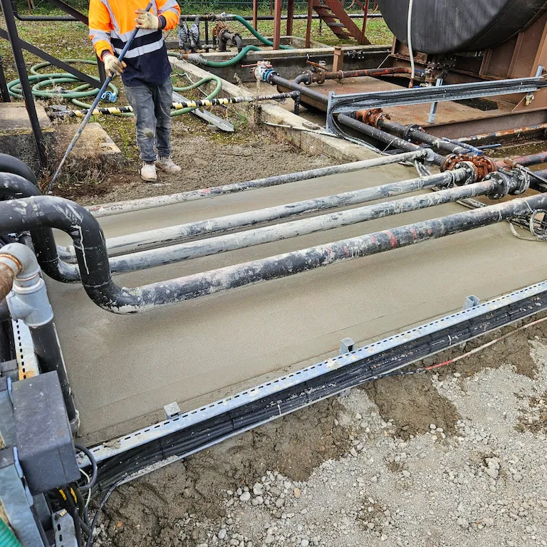 Reinforced concrete oil bund being poured under live pipelines in Horndean, Hampshire